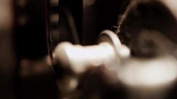 primer plano extremo del proyector de películas de 8 mm y detalle de la película que se mueve sobre los rodillos en 4k video