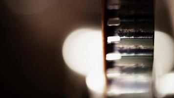 Primer plano frontal extremo del proyector de películas de 8 mm y detalle de los fotogramas de la película en 4k video