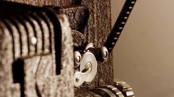 Gros plan extrême du projecteur de film 8 mm et détail du mécanisme de pignon avec film et rouleaux en action en 4k video