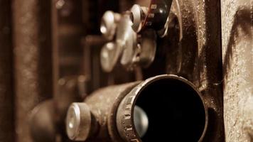 Extreme close up of 8mm movie projector showing the lens projecting and the sprocket mechanism in 4K video