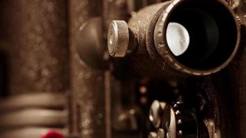 Primer plano extremo de un proyector de películas de 8 mm que muestra una lente polvorienta y oxidada que se proyecta en 4k