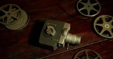 Panning shot of several film reels and an ancient camera on a table in 4K video