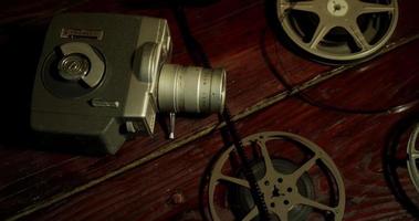 Slow panning shot of three film reels and an ancient camera on a table in 4K video