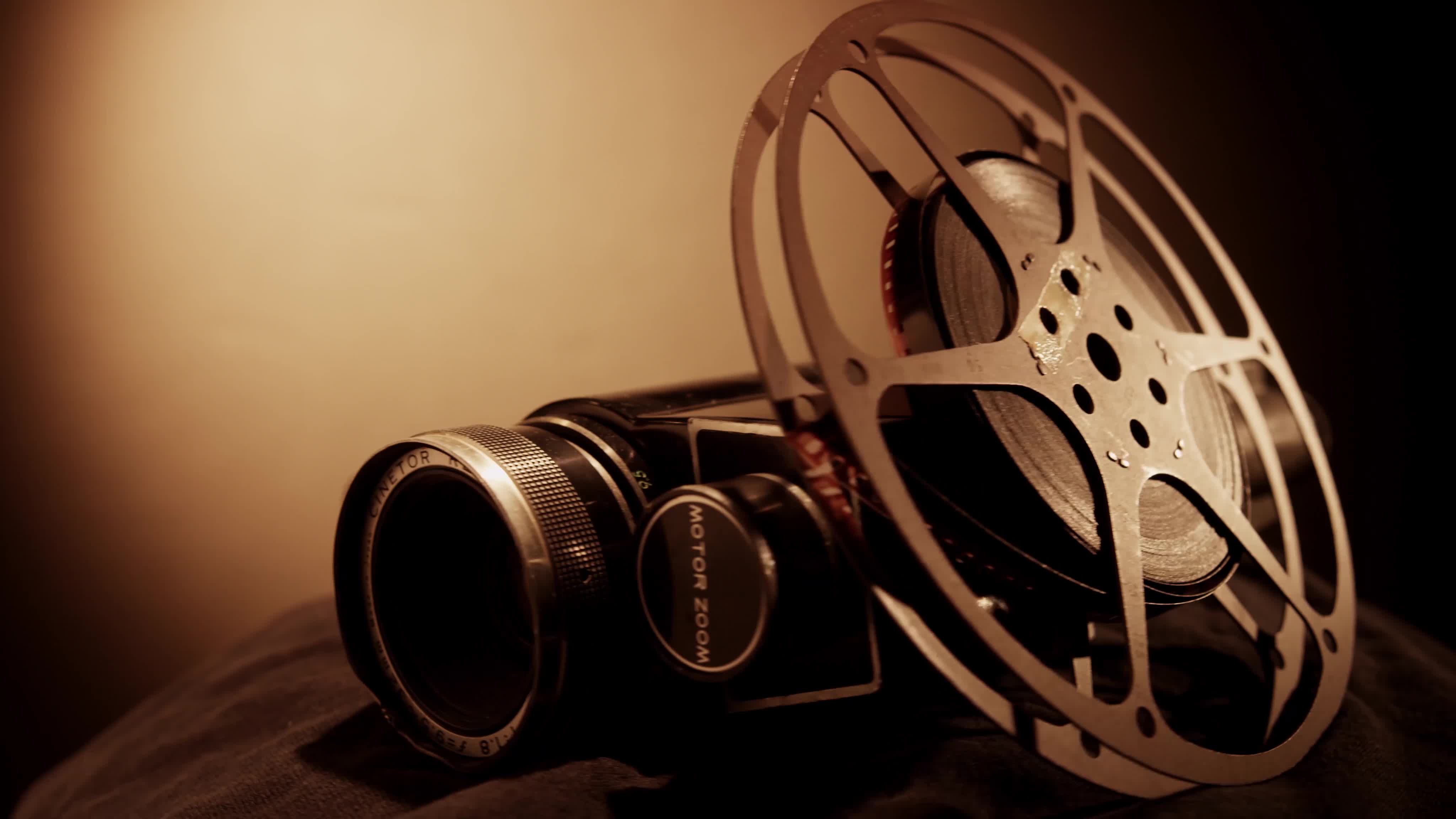 Clip of film reel and classic camera spinning with right side light and