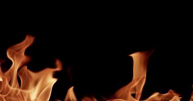 hete bornfire gloeit op donkere achtergrond voor vlamonderwerpen in slow motion van 4 k video