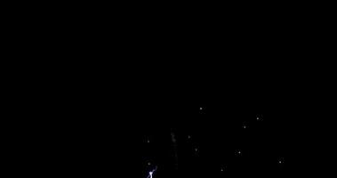 Feuerwerk mit lila Flammen und weißen Funken am Nachthimmel in 4k video