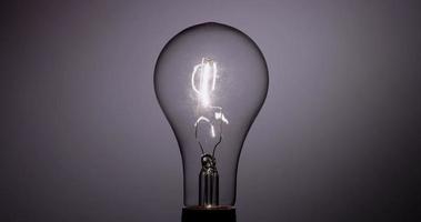 Classic light bulb turning on and turning off with vertical filament in 4K video