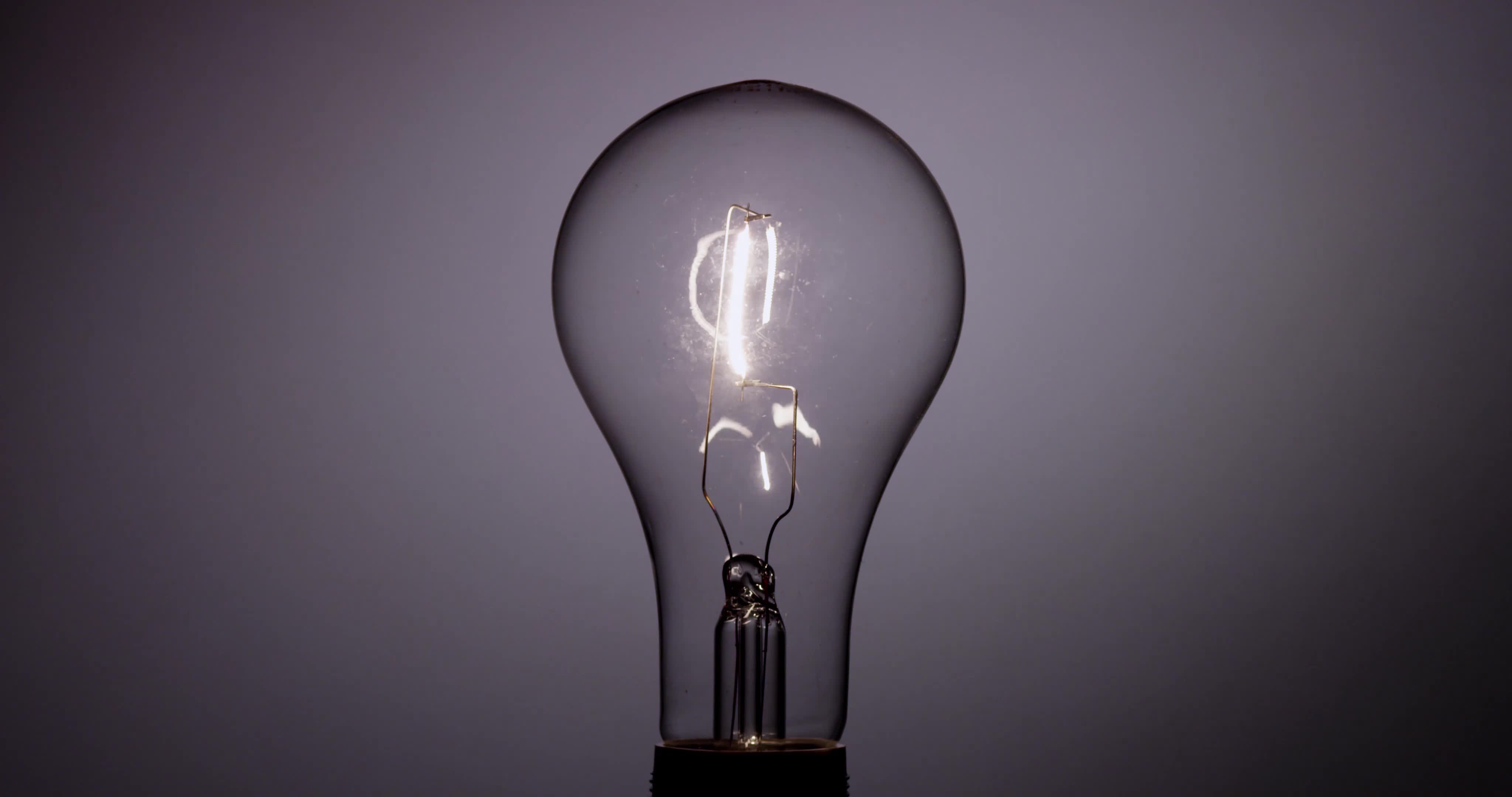 Classic light bulb flickering with vertical filament in 4K 1616563