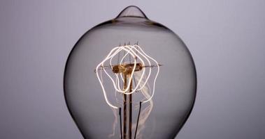 close-up vista frontal de uma lâmpada vintage acendendo e apagando com filamento de mola em 4k video