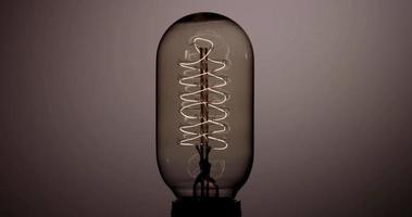 ampoule à balle verticale clignotant rapidement avec un filament hélicoïdal chaud en 4k