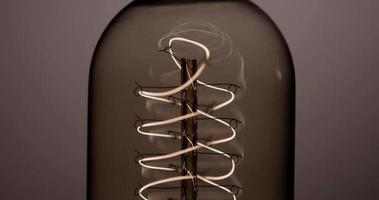 close-up extremo de lâmpada de bala com filamento de hélice ligando e desligando em 4k video