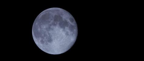 nachtscène van volle maan die langzaam beweegt op donkere hemel met enkele wolken op de voorgrond in 4k