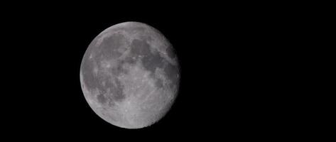 Nocturnal shot of full moon moving slowly in the center of the scene in 4K