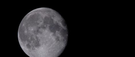 Detail of full moon moving very slow in dark sky in 4K video