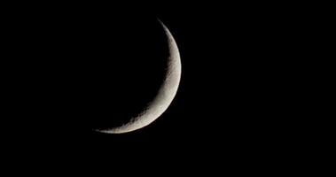 Night outdoor shot of the moon. Waxing crescent moon crossing the scene in diagonal path. Ideal for your astronomy projects or Halloween topics in your footage. 4K 4096 x 2160 | 24 fps