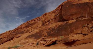 Traveling shot of rock hill in desert landscape drawing a diagonal scene of blue and red in 4K video