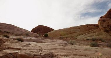 foto mista de colinas rochosas na paisagem do deserto, primeiro uma foto panorâmica indo para a esquerda e, em seguida, uma foto móvel vertical subindo em 4k video