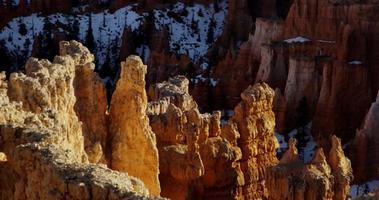  Aerial shot of red rock hills with snowy mountains in background in 4K video