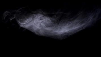 Little smoke cloud floating on dark background and disappearing in 4K video