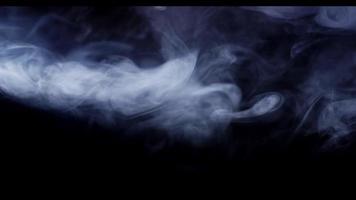 tätt moln av vit rök försvinner i övre delen av mörk scen i 4k