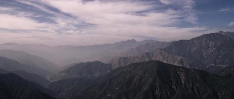 grandi montagne scure con belle nuvole che si muovono da sinistra a destra della scena in 4K video