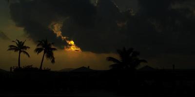 Timelapse of sunset in tropical landscape with palm trees in foreground in 4K video