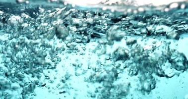 blaue Szene von Spritzwasser und Blasenbildung in klarem Behälter in 4k video
