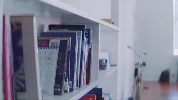 yong kvinna väljer en bok från en bokhylla video
