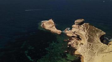 Drone unveiling shot of a lighthouse from a reef in 4K video