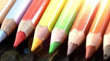 On a wooden background multi-colored pencils. Bright colored pencils Close up. Macro. Macro shooting video