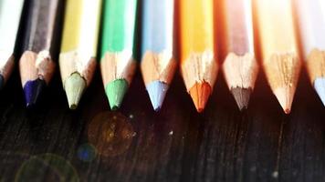 On a wooden background multi-colored pencils. Bright colored pencils Close up. Macro. Macro shooting video