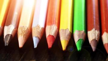 On a wooden background multi-colored pencils. Bright colored pencils Close up. Macro. Macro shooting video