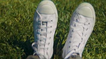 Cerca de zapatillas blancas sobre el césped
