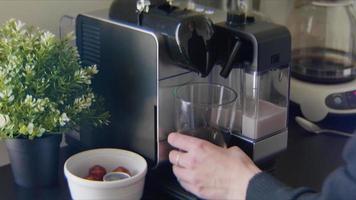 Mujer joven hace un espresso macchiato en su cocina video