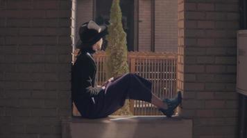Woman Seated In A Window Of A Building Looking To The Street video