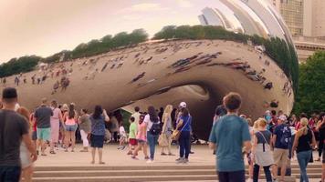 Les gens qui marchent et prennent des photos du haricot à Chicago video