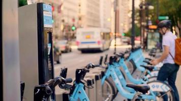 Joven tomando una bicicleta pública azul en Chicago video