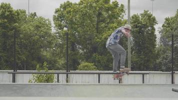 foto média de um homem fazendo um truque de skate no corrimão e caindo