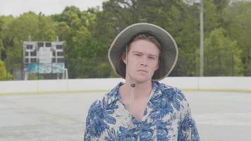 jeune homme, à, chapeau, dans, a, patinoire, regarder appareil-photo video