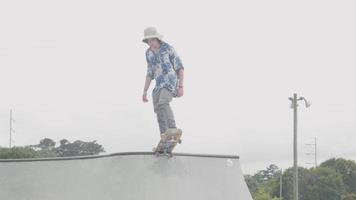 hombre en la cima de una rampa patinando y acercándose video