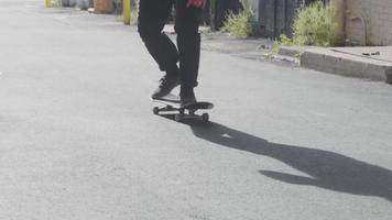 patineur se déplaçant dans la ruelle et pratiquant des tours de planche à roulettes video