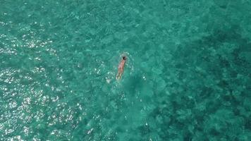 drone sigue a un nadador en el mar en 4k video