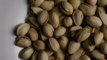 Cinematic, rotating shot of pistachios on a white surface - PISTACHIOS 030 video