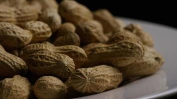 filmische, rotierende Aufnahme von Erdnüssen auf einer weißen Oberfläche - Erdnüsse 029