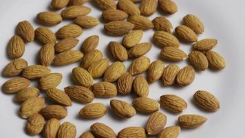 Plan cinématique et rotatif d'amandes sur une surface blanche - amandes 006 video