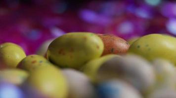 Foto giratoria de coloridos dulces de Pascua sobre un lecho de pasto de Pascua - Pascua 156 video