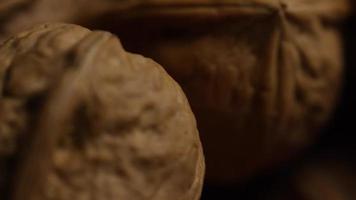 Cinematic, rotating shot of walnuts in their shells on a white surface - WALNUTS 079 video