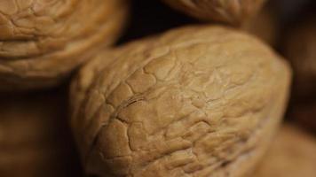 Cinematic, rotating shot of walnuts in their shells on a white surface - WALNUTS 062 video