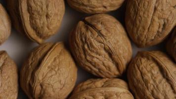 Cinematic, rotating shot of walnuts in their shells on a white surface - WALNUTS 007 video