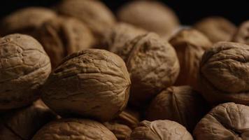 Cinematic, rotating shot of walnuts in their shells on a white surface - WALNUTS 088 video